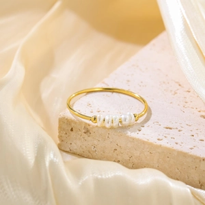 Detail of thin gold titanium steel ring with five baroque freshwater pearls on stone