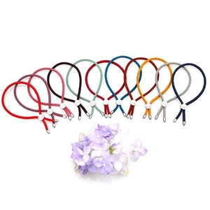 Detail of 11 colorful elastic hair bands with silver leaf-shaped metal buckle on floral background