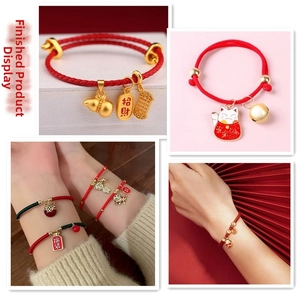 Detail view of handmade red braided bracelets with gold-plated lucky charms and tiger charms