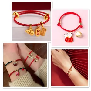 Adjustable red braided rope bracelet with traditional gold lucky charms for women