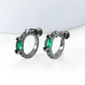 Close-up of gunmetal C-shape earrings with marquise green gemstones and screw-back detail