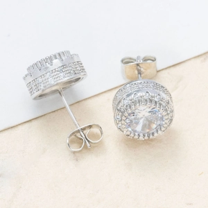 Macro detail of silver round halo stud earrings with micro-paved cubic zirconia stones