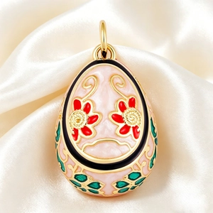 Detail of Faberge-style egg pendant with pink enamel and intricate red floral patterns