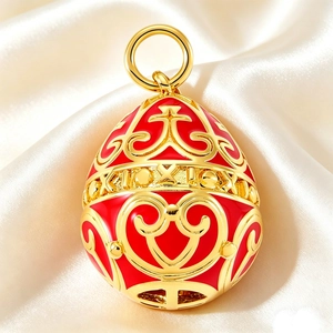 Close-up of Faberge style red enamel egg pendant with gold filigree on silk