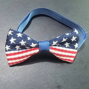 Detail of US flag pet bowtie with white stars and red stripes on dark leather texture