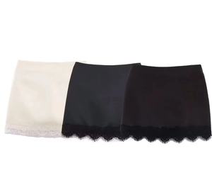 Detailed view of layered satin slip skirt extenders with wide eyelash lace hem in white and black