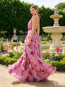 Pink floral halter maxi dress with ruffled tiers in a romantic summer garden setting