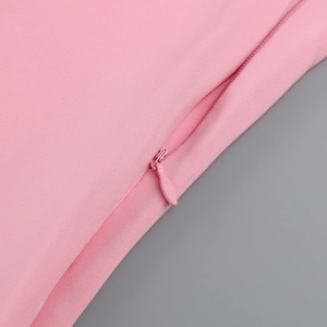 Detailed macro view of invisible zipper closure on light pink fabric dress