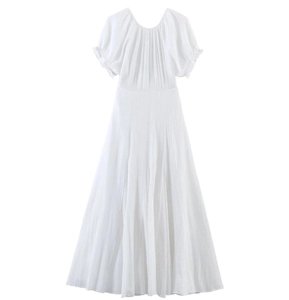 Detailed view of white pleated midi dress with high waist and textured fabric detail