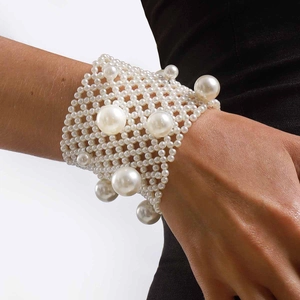 Detailed view of wide multi-layer elastic pearl beaded bracelet on a woman wrist
