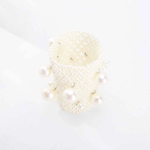 Close-up of wide woven multi-row pearl ring with hanging pearl charms and honeycomb texture