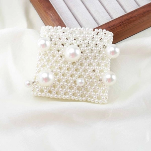Detailed close-up of multi-layer white pearl beaded bracelet on elegant silk background