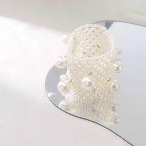 Detail of wide multi-strand pearl bracelet with large decorative pearls on a heart mirror
