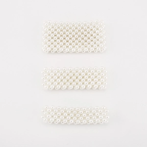 Detail of three cream white handmade pearl woven hair clips in various widths