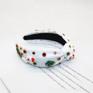 Detail of white knotted headband with Santa charms and colorful rhinestone accents