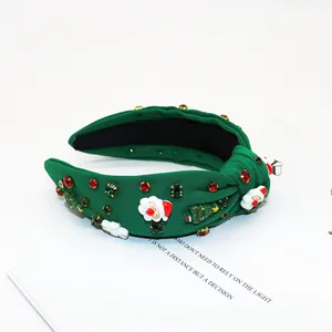 Close-up of green knot headband with rhinestone Santa and Christmas tree charms