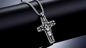 Macro view of vintage religious cross pendant with holy icons and embossed dove