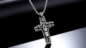Macro view of vintage cross pendant with relief carving and antique oxidation finish