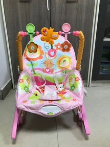 Detail of pink baby rocker with adjustable toy bar and secure three-point safety harness