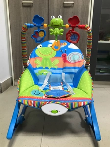 Detail of baby rocker featuring 3-point safety harness and music vibration control panel
