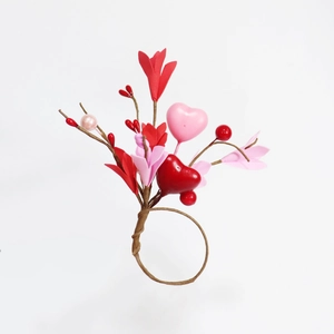 Festive pine needle napkin ring with red heart accents and faux berries for holiday tables