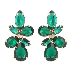 Detailed view of green glass leaf earrings with gold-tone prong settings and marquise stones