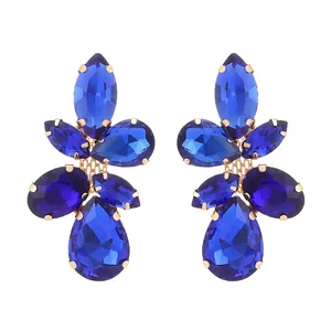 Detailed view of vintage gold earrings with navy blue leaf-shaped crystal clusters