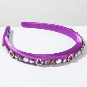 Detail of purple satin headband with colorful rhinestones and handmade inner label
