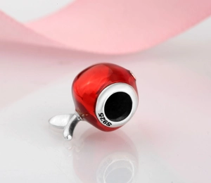 Macro shot of S925 sterling silver red apple charm with glossy finish and leaf detail