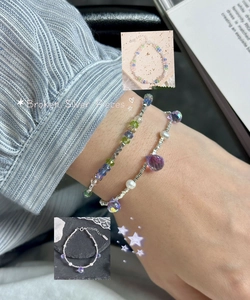 Detail of layered S925 silver bracelets with purple crystals, pearls and broken silver pieces