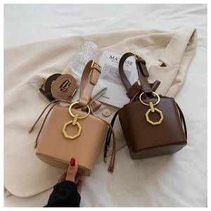 Detail of vintage bucket bags with matte leather texture and elegant gold metal hardware