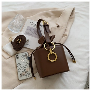 Detail of vintage brown bucket bag with gold ring handle and drawstring closure