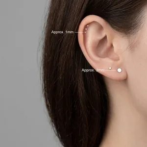 Orecchini a perno minimalisti in argento S999 da 1mm e 3mm indossati all'orecchio