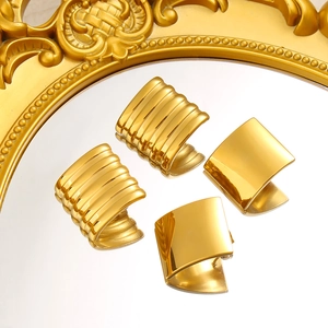 Minimalist 18K gold-plated ribbed hoop and polished square earrings on a vintage mirror