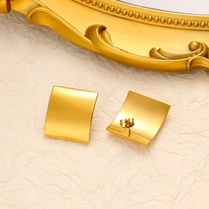 Detailed view of square 18K gold plated stainless steel studs on a vintage prop