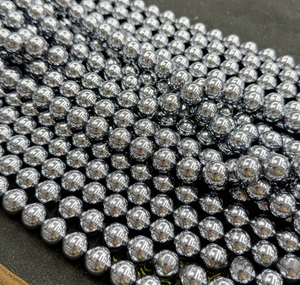Close-up of polished silver Terahertz faceted beads with high metallic mirror luster for DIY jewelry