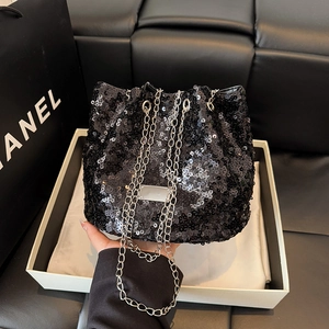 Detailed view of black sequin bucket bag with silver metal chain and glossy texture