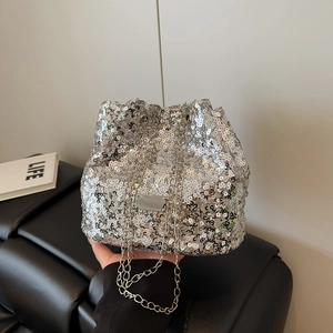 Detail of silver sequin bucket bag with metal chain strap on premium leather background