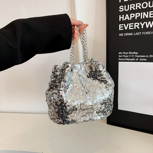 Detail of silver sequin bucket bag with metal chain handle and drawstring closure