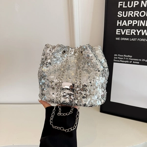 Close-up of sparkling silver sequin bucket bag with elegant metallic chain strap detail