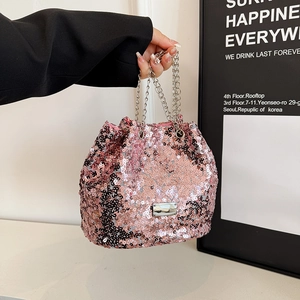 Macro shot of pink sequin bucket bag featuring a silver chain and metal plate detail
