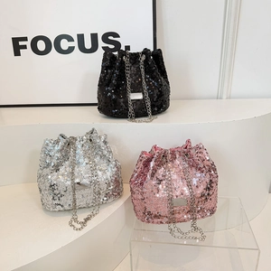 Detail view of sequin bucket bags in black, silver, and pink with metal chain straps