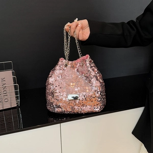 Detail of pink sequin bucket bag featuring metallic gold chain and drawstring closure