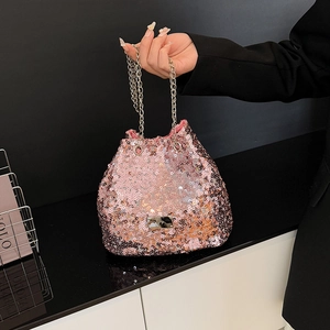 Close-up of pink sequin bucket bag with golden chain handle and metallic logo plate