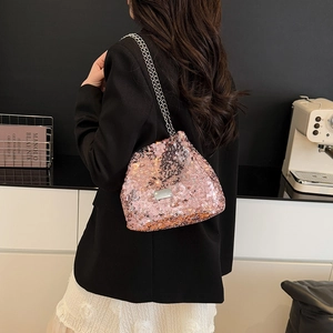 Pink sequin shoulder bag with silver chains worn over a black blazer for urban style