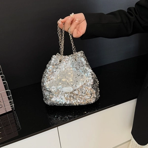 Detail of shimmering silver sequin bucket bag with elegant metal chain handles
