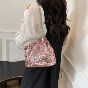 Detailed view of pink sequin bucket bag with silver metal chain strap on model