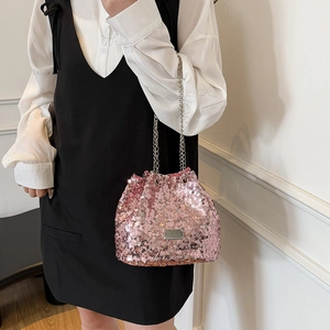 Detail of pink sequin bucket bag with silver chain strap and polished metal plate