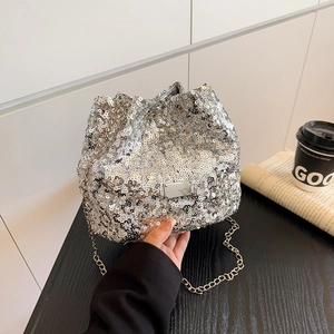 Detailed shot of silver sequined bucket bag with metallic chain and drawstring closure