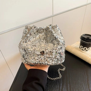 Detailed view of a silver sequin bucket bag with metal chain strap and drawstring closure